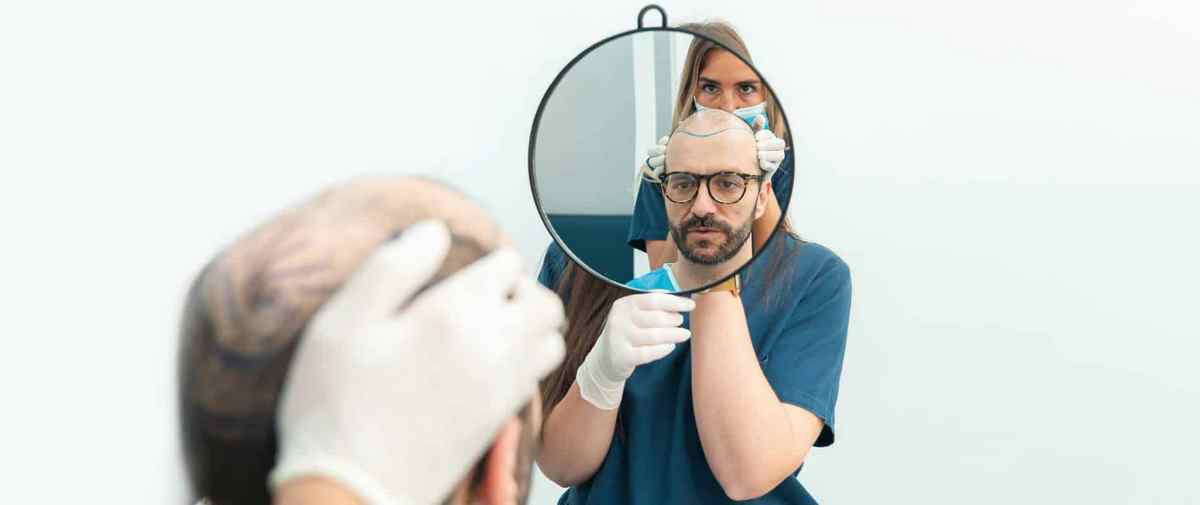 Imagem de uma enfermeira a definir a zona a transplantar no paciente no dia do transplante capilar.